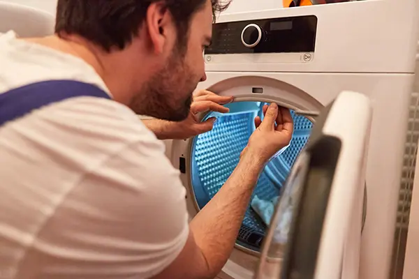 Technician performing dryer vent cleaning maintenance