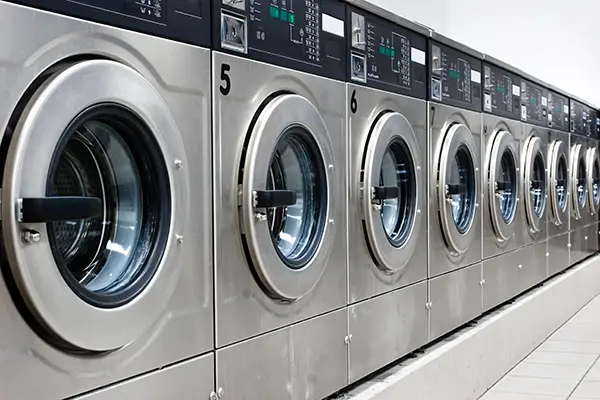 Line of silver washing machines at laundromat
